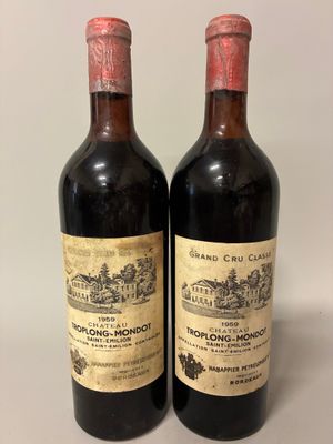 two bottles of red wine sitting next to each other on a table