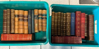two blue bins filled with old books on a tiled floor