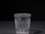 a shot glass sitting on a table with a black background