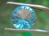 un gros plan d'un diamant bleu tenu par une pince