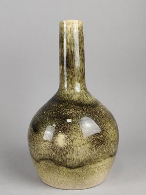 un vase vert posé sur une table