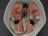 a white bowl with a pair of orange gloves in it