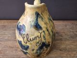 a small vase with writing on it sitting on a table