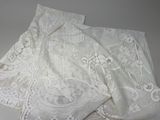 tissu en dentelle blanche orné de fleurs et de feuilles blanches sur fond gris