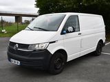 La camionnette blanche est garée sur le parking à côté d'un pont.