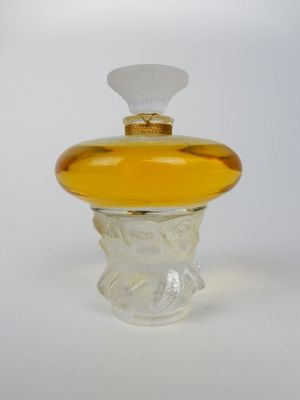 flacon de parfum en verre jaune avec un bouchon blanc et un capuchon doré