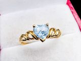 a close up of a gold ring with a blue topaz stone