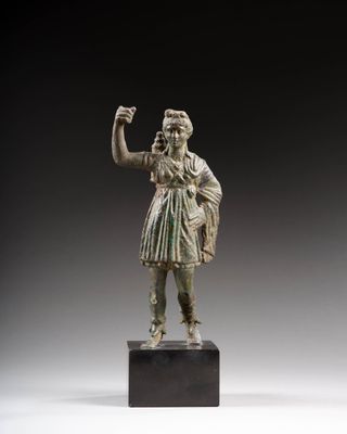 une image représentant une statue en bronze d'une femme tenant une coupe