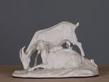 a white statue of a goat and a calf on a table