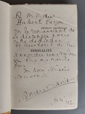 un livre ouvert avec une écriture dessus, posé sur une table