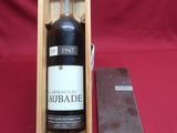 une vieille bouteille de rhum dans une boîte en bois, à côté d'un couteau