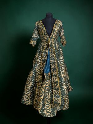 a green and gold dress on a mannequin mannequin mannequin mannequin mannequin mannequin mannequin mannequin mann
