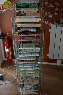 une étagère métallique sur laquelle sont posés de nombreux livres, dans une pièce