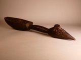 a wooden spoon with a long handle on a white surface