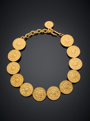 un bracelet en or orné d'un motif de pièce de monnaie sur fond noir