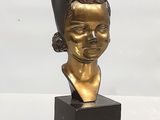 buste en bronze d'une femme coiffée d'un chapeau, posé sur un socle en marbre