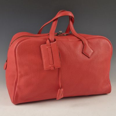 un sac de voyage en cuir rouge posé sur une table