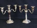 two silver candelabs on a black background with a black background