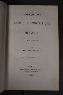 un livre ouvert posé sur une table, à côté d'une plante