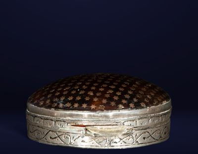 une boîte en argent ornée d'un motif noir et or