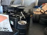 a pile of junk in a garage next to a pile of tires