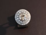 a diamond ring on a black surface with a shadow