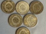 six pièces de monnaie britanniques disposées en forme de cœur sur un fond blanc