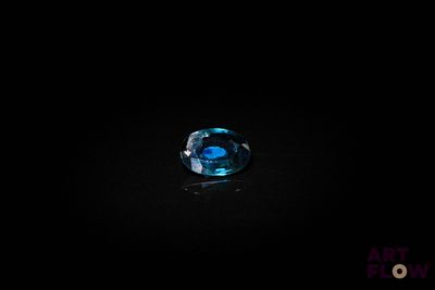 un gros plan d'un anneau bleu sur une surface noire