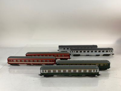 plusieurs petits trains sont alignés sur une surface blanche