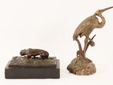 pair of bronze sculptures of birds and a frog on a rock