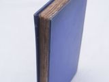 an open blue book sitting on top of a white surface