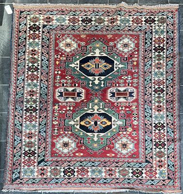 un tapis rouge, bleu et vert posé sur un sol carrelé