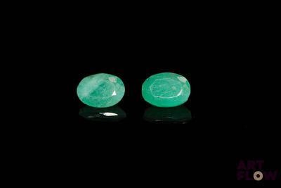 une paire de boucles d'oreilles en émeraude sur fond noir