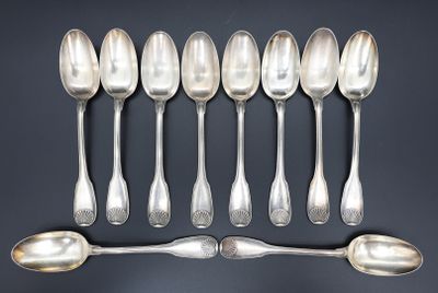 six cuillères en argent sont alignées sur une table