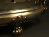an antique silverplated footed bowl with handles on a black background