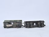 two black trains sitting side by side on a white surface