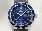 La montre est bleue et argentée, avec un cadran noir.