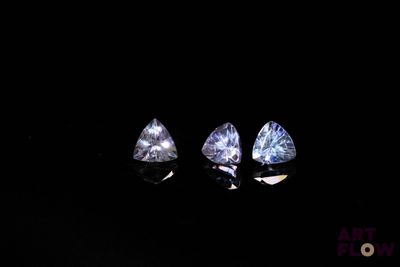 three trillion cut diamonds in the dark with a reflection on the ground