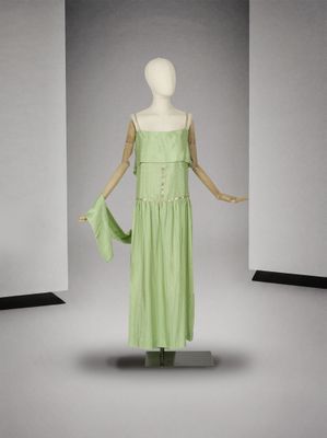 un mannequin vêtu d'une robe verte dans une pièce