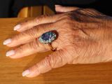 a close up of a person ' s hand with a ring on it