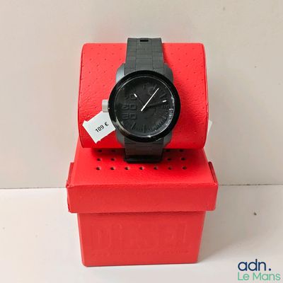 a black watch sitting on a red box with a price tag