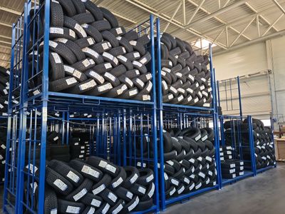 a lot of tires stacked on a rack in a warehouse