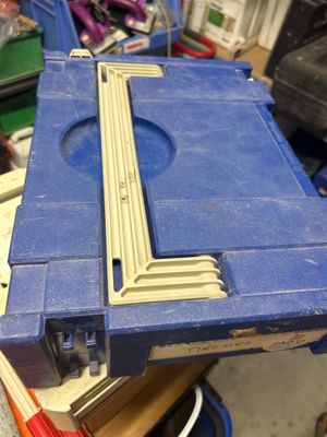une boîte à outils bleue contenant un morceau de bois