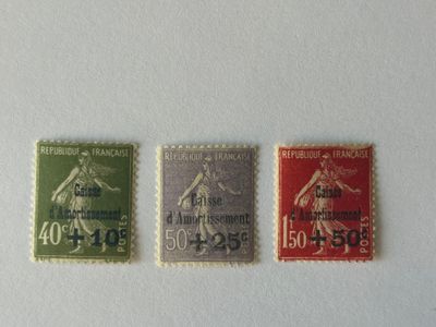 trois timbres de couleurs différentes sur un fond blanc