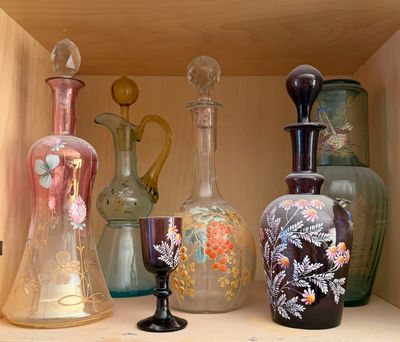 many different vases on a shelf in a cabinet