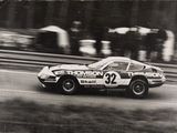 une photo en noir et blanc d'une voiture de course sur le circuit