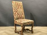 an old chair with a floral upholstered seat on a wooden floor