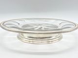 a silver plate with a glass bowl on top of it