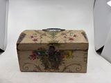 a small wooden box with a floral design on it