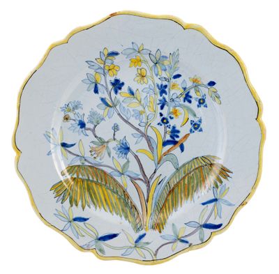 a blue and yellow plate with a bird and flowers on it
